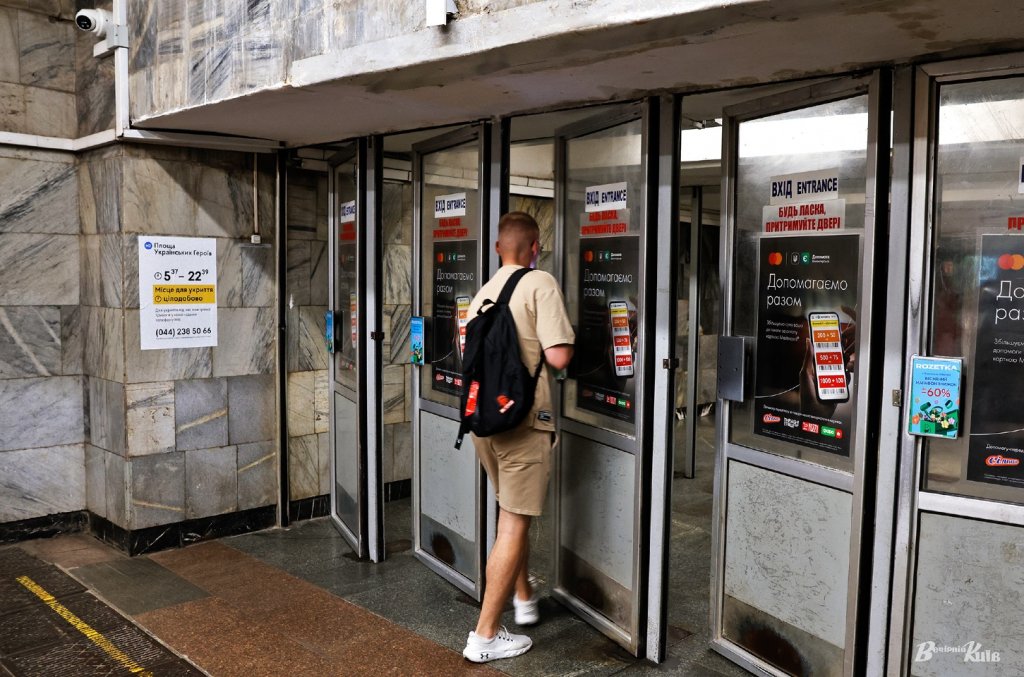 Чоловік входить в метро через маятникові двері